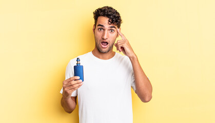 hispanic handsome man looking surprised, realizing a new thought, idea or concept. vaporizer concept