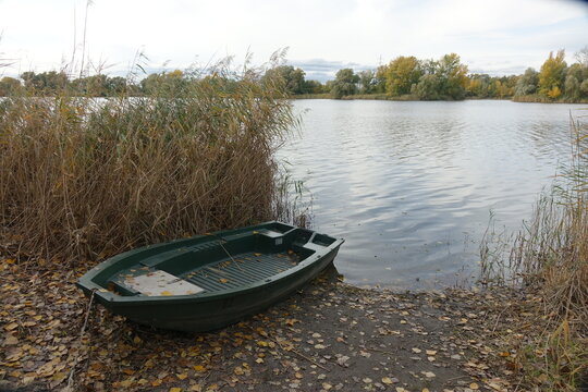 Colourful boats tied up at the shore of Blaue Adria recreational area and natural habitat on an autumn day, Altrip Germany