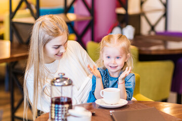 Mom and daughter play hide-and-seek in a cafe. Fun game