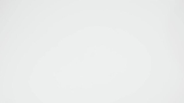 The coffee beans spin rotate quickly fast fly, dispart, splash to the sides with centrifugal coriolis force. Video reverse. Coffee beans twist, create pattern, make design shape square rectangle.