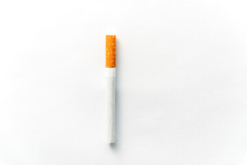 Single cigarette on white background. Copy Space. Close up.
