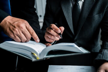 Close up of businessmen or lawyers discussing contract or business agreement at law firm office,...