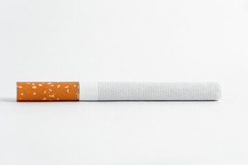 Single cigarette on white background. Copy Space. Close up.