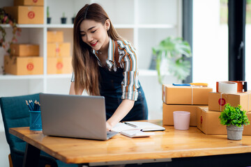 Portrait of Asian young woman SME working with a box at home the workplace.start-up small business owner, small business entrepreneur SME or freelance business online and delivery concept.