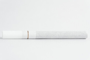 Single cigarette on white background. Copy Space. Close up.