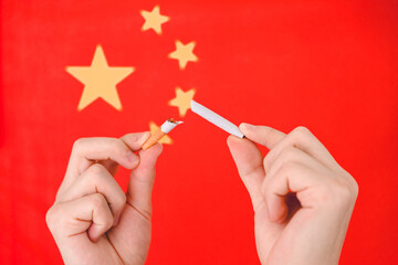 Hand breaks a cigarette in the background of the China