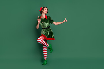 Fototapeta na wymiar Full length body size view of attractive cheerful girl elf dancing having fun resting isolated over green color background