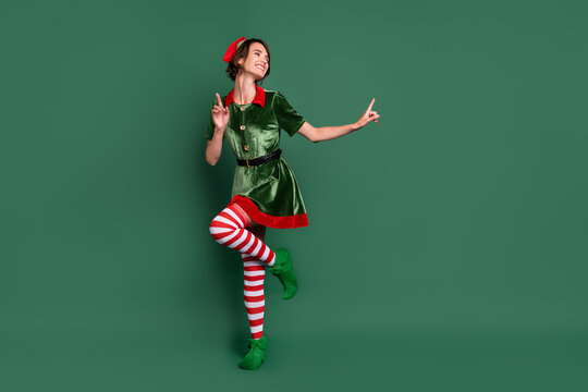 Full length body size view of attractive cheerful girl elf dancing having fun resting isolated over green color background