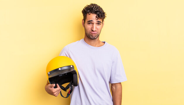 hispanic handsome man feeling sad and whiney with an unhappy look and crying. motorbike helmet concept