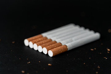 Seven cigarettes on a black background . Inserted in one