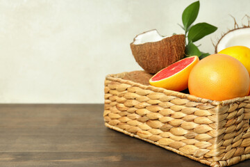 Basket with exotic fruits on wooden table