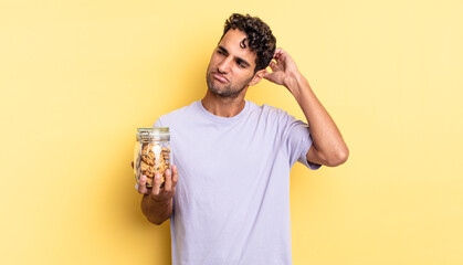 hispanic handsome man smiling happily and daydreaming or doubting. cookies concept