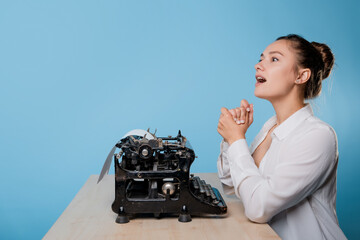 young woman writer at a typewriter, is inspired, is passionate about writing a text. Young brunette...