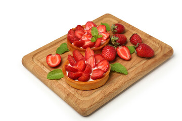 Cutting board with strawberry tarts on white background