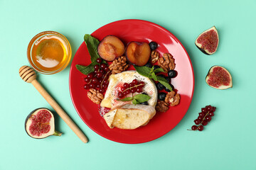 Fototapeta na wymiar Concept of tasty food with grilled camembert on mint background