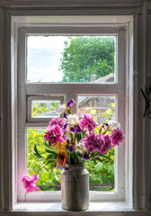 Old window and a bouquet of pink peonies	