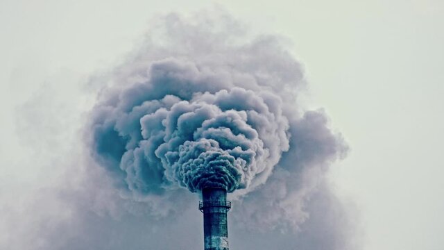 This smoke coming from the chimney in a factory. Harmful emissions into the atmosphere, from the pipe. Serious damage the environment. Plant stack Coaling station. Close up shot. Dark sad view.