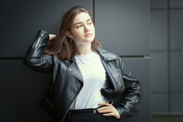 Portrait of a young woman in an autumn black leather jacket. Modern urban style clothing black...