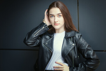 Portrait of a young woman in an autumn black leather jacket. Modern urban style clothing black leather jacket.