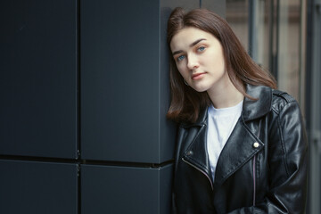 Portrait of a young woman in an autumn black leather jacket. Modern urban style clothing black...