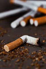 A pack of cigarettes and a bunch of cigarette butts