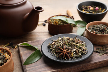 Different dry aromatic teas on wooden table