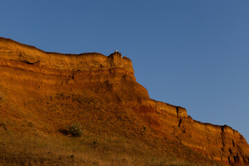 Geology. Desert landscape. Panorama view of the sandstone formation, the rocky cliffs, sand. Background or texture of sandy cliff on the coast, orange limestone