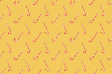 Seamless New Year's pattern from red and white caramel on yellow background