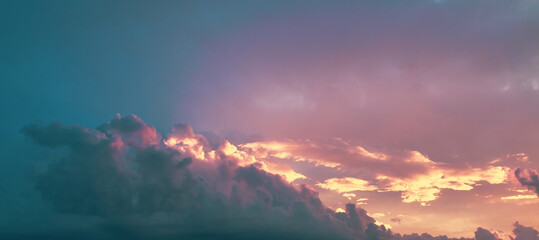 cloudy sky with golden and pink tint of clouds at sunset