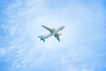 Plane flying in the blue sky with white clouds