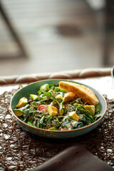 Green avocado salad with toast dish on a restaurant table