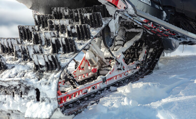 a caterpillar of a sports snowmobile in close-up against the background of a mountain valley. the concept of recreation on a mountain snowmobile in winter. snow bike rear view in detail