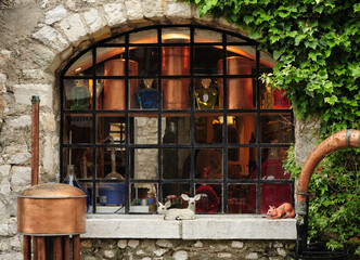 Looking Through A Window Into A Lavender Shop Decorated With Distillation Equipment in Gourdon France