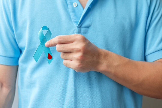November World Diabetes day Awareness month, man holding light Blue Ribbon with blood drop shape for supporting people living, prevention and illness. Healthcare, prostate cancer day concept
