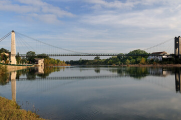 River Ardeche Reflecting The Ancient Suspension Bridge In Saint Martin D'Ardeche France On A Beautiful Autumn Day With A Few Clouds In The Blue Sky