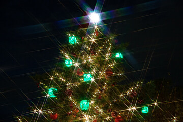 Christmas tree with sparkling lights against black background