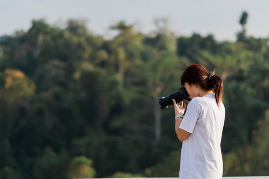 Female photographer taking pictures with natural background