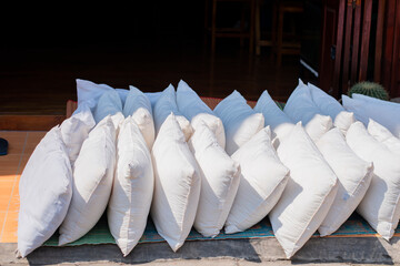 Many pillows are laid out in the sun.