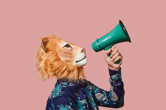 Man Wearing A Lion Mask Speaks Into A Megaphone