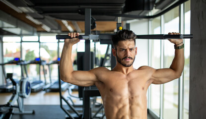 Fototapeta na wymiar Young fit man exercising in a gym. Sport people healthy lifestyle concept