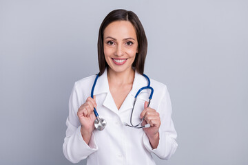 Photo of mature woman happy positive smile hold stethoscope clinic diagnostics doctor isolated over grey color background