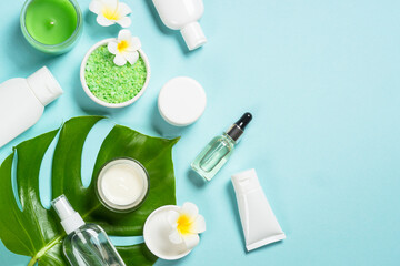 Natural cosmetic products, spa background at blue. Cream, mask, lotion and sea salt. Top view image with copy space.