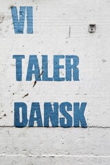 We speak Danish message on a wall called vi taler dansk in Danish language