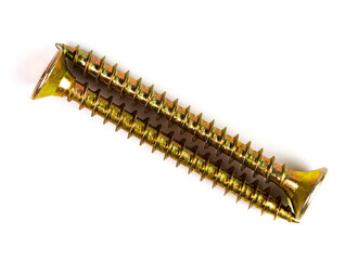 Two screws from yellow metal on white isolated, close-up, top view.