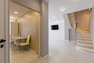 Fototapeta premium interior of a large living room with gray walls and stairs in a modern style
