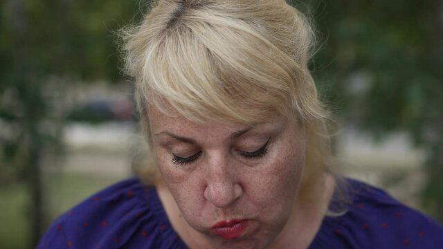 Fat mature woman eating a bun