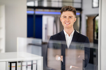 Handsome businessman with arms crossed in office