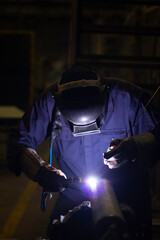 Obraz na płótnie Canvas Skillful welders weld steel in the factory. Construction site metal welder. builder wear fireproof gloves for safety at work.