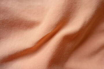 Folded apricot colored simple cotton jersey fabric