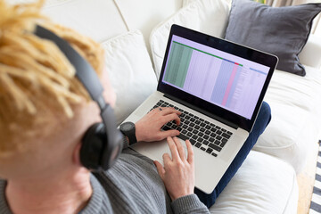 Albino african american man in the living room using laptop